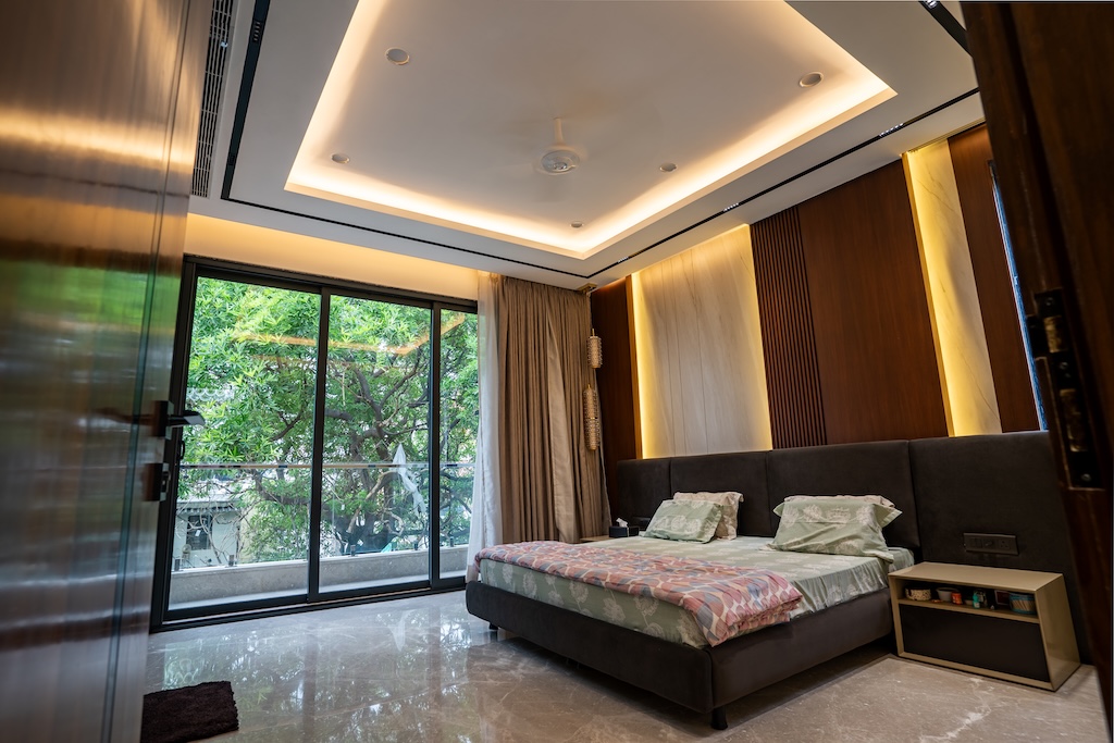 ZuildUp interior — master bedroom with wood-paneled accent wall and cove lighting